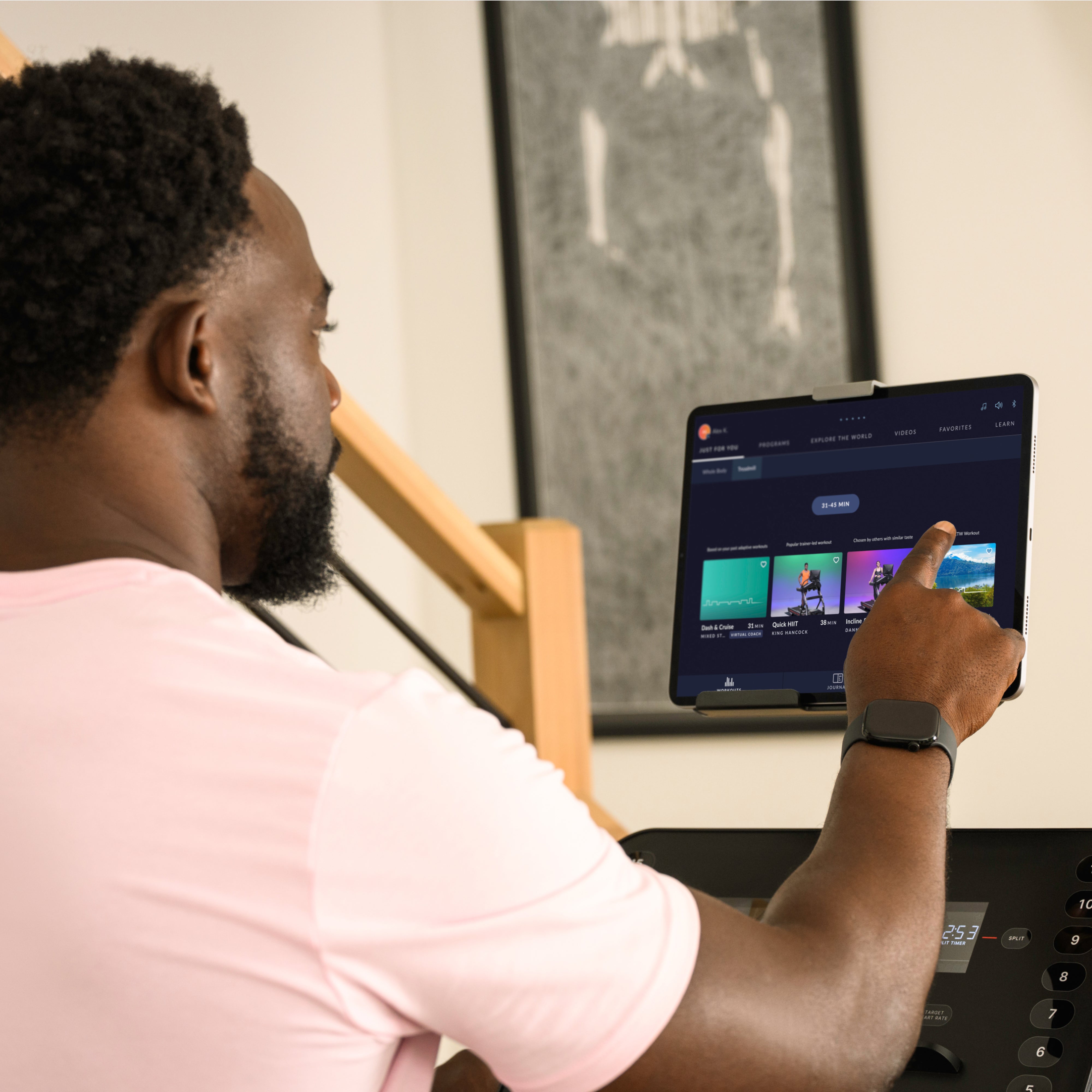 Person using a tablet with a music streaming app on a treadmill